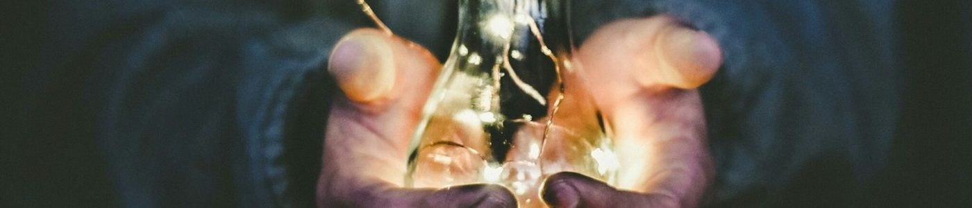 Photo by Riccardo Annandale man holding incandescent bulb